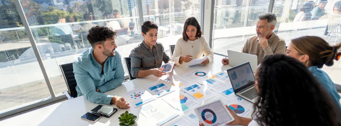 profissionais em mesa de trabalho analisando dados