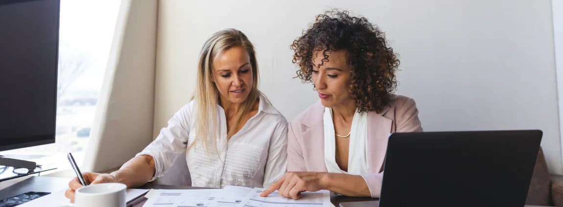 mulheres em escritório analisando papéis e planejando rotas