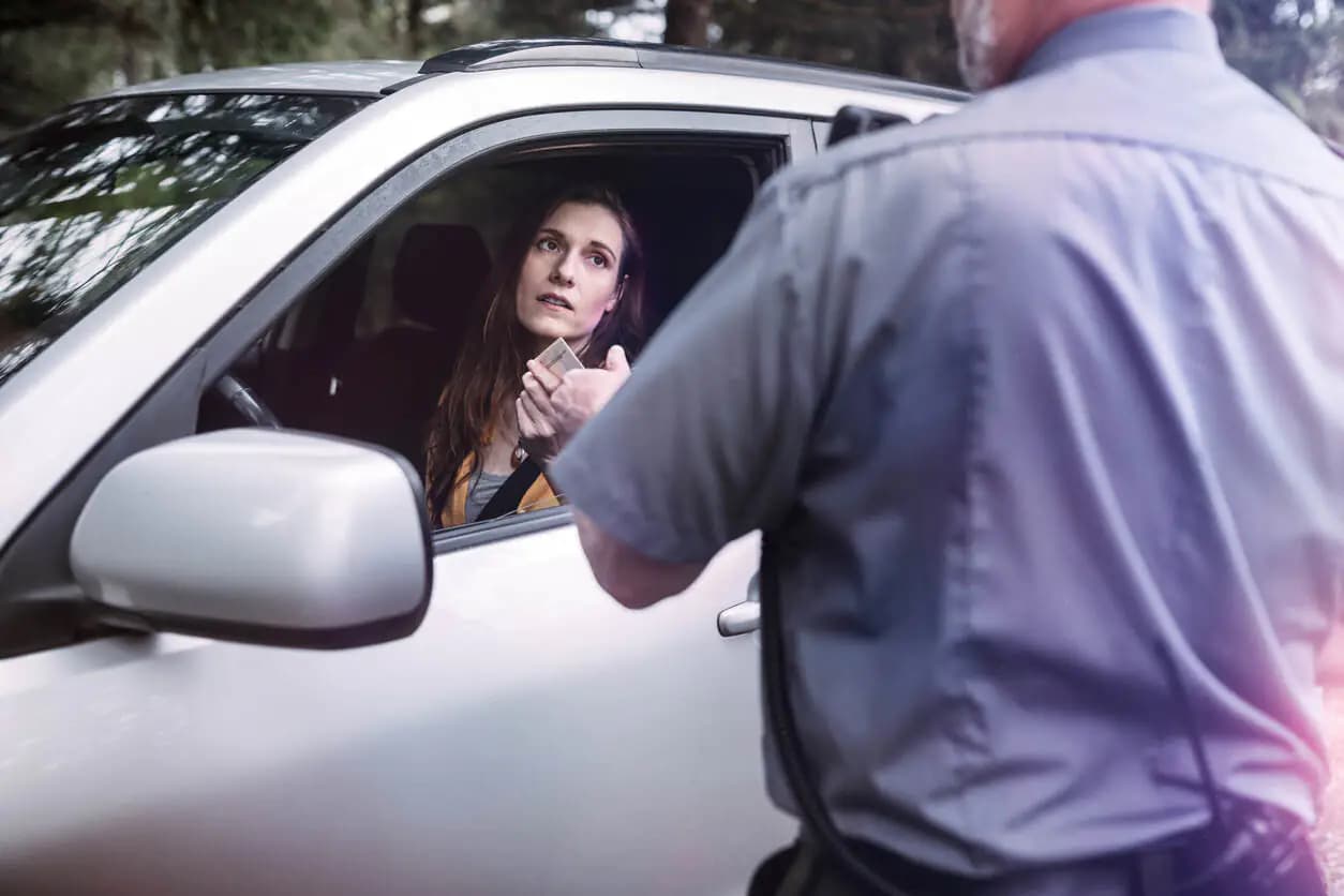 Mulher dentro do carro levando uma multa de trânsito