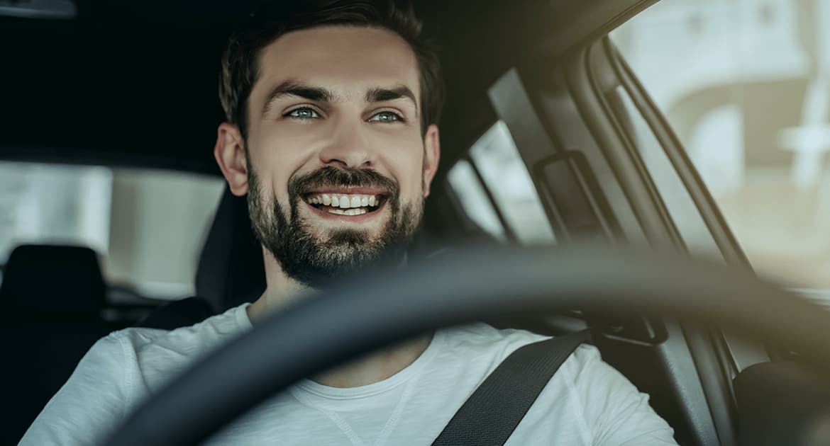 Imagem de um homem jovem no volante representando o conteúdo sobre Perfil de condutor de frotas