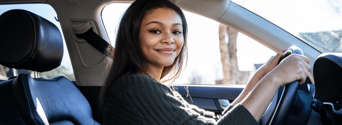 Imagem de uma mulher dirigindo para ilustrar o conteúdo sobre direção ofensiva e como adotar ela no trânsito Imagem de uma mulher dirigindo para ilustrar o conteúdo sobre direção ofensiva e como adotar ela no trânsito