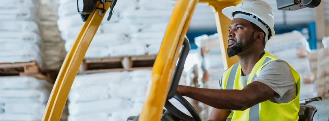 homem dirigindo uma empilhadeira dentro do estoque homem dirigindo uma empilhadeira dentro do estoque