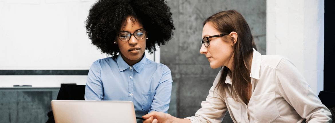 Imagem de duas mulheres olhando para um notebook Imagem de duas mulheres olhando para um notebook