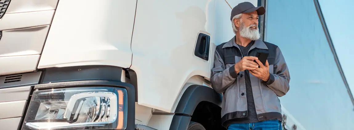 homem segurando celular ao lado do caminhão homem segurando celular ao lado do caminhão