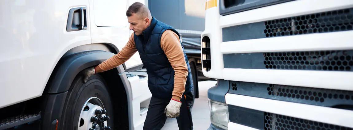 homem tocando no pneu do caminhão homem tocando no pneu do caminhão