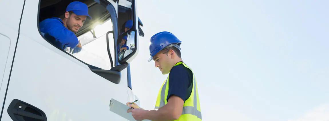 Motorista dentro do caminhão toco conversando com funcionário Motorista dentro do caminhão toco conversando com funcionário