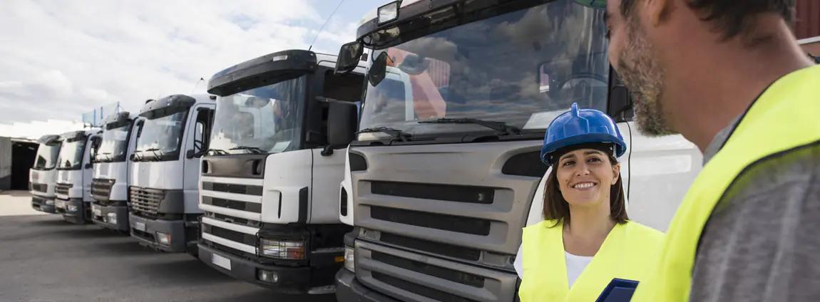 mulher e homem conversando em frente da frota de veículos pesados mulher e homem conversando em frente da frota de veículos pesados