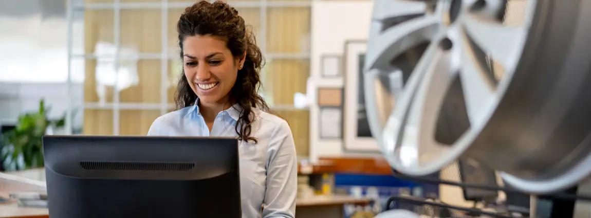 mulher auxiliar de frota sorrindo em frente ao computador mulher auxiliar de frota sorrindo em frente ao computador