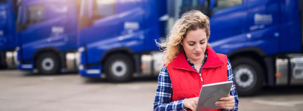 mulher usando tablet ao lado da frota de caminhões mulher usando tablet ao lado da frota de caminhões