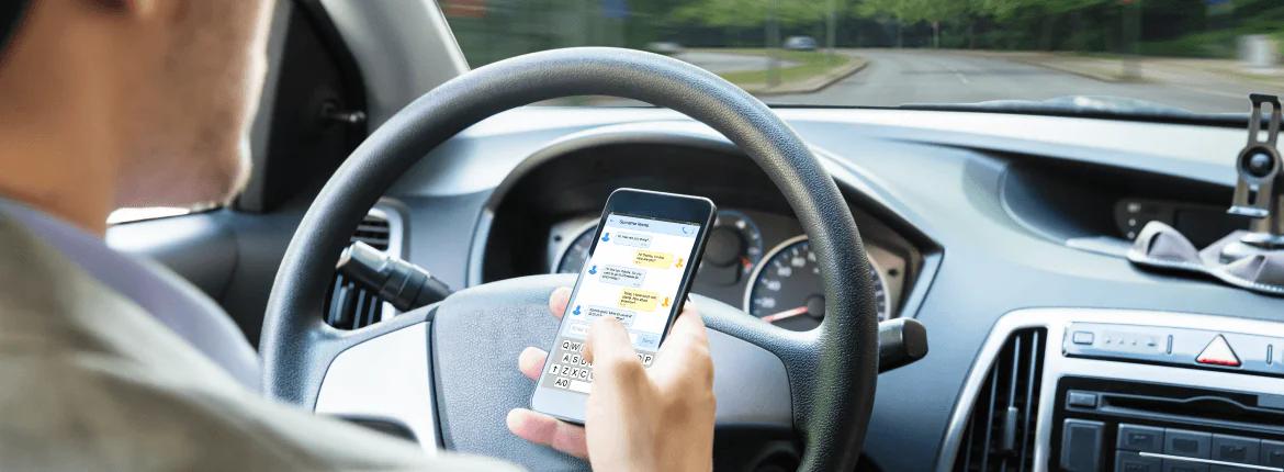 Um homem dirigindo enquanto usa o celular Um homem dirigindo enquanto usa o celular