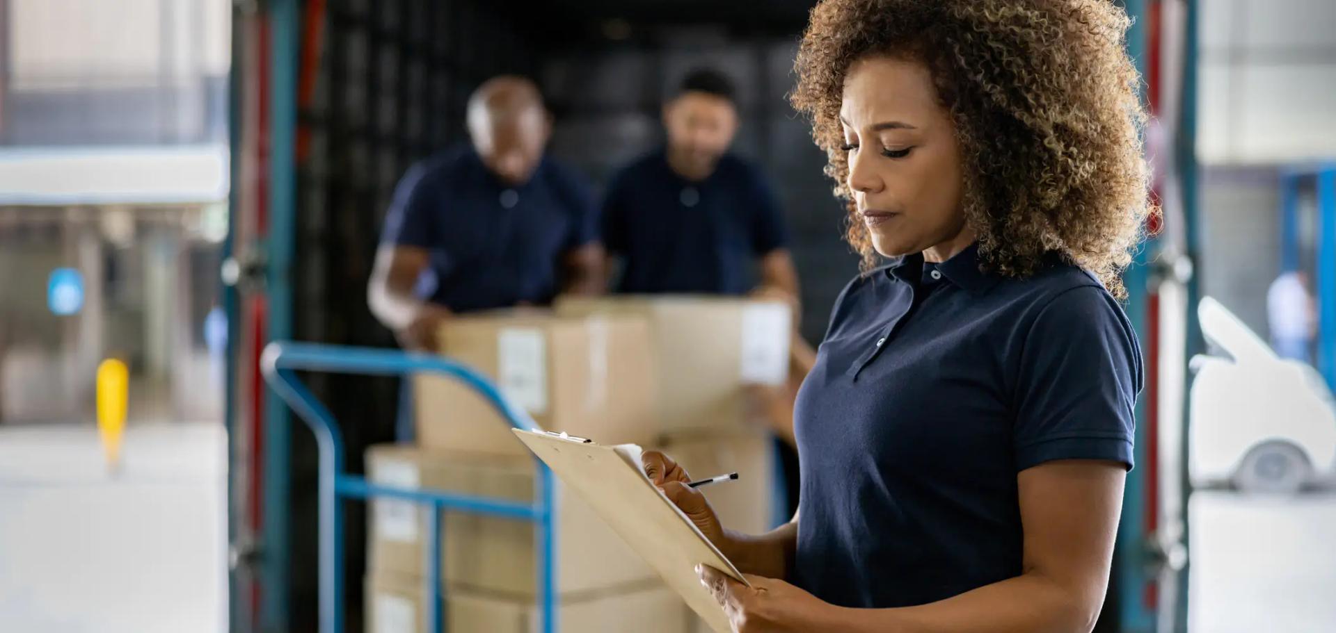 Mulher confere dados de tara do caminhão durante abastecimento do veículo Mulher confere dados de tara do caminhão durante abastecimento do veículo