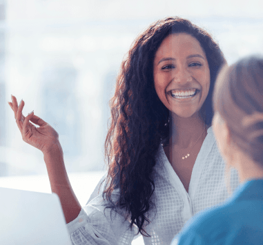 Imagem de duas mulheres conversando e uma está sorrindo Imagem de duas mulheres conversando e uma está sorrindo