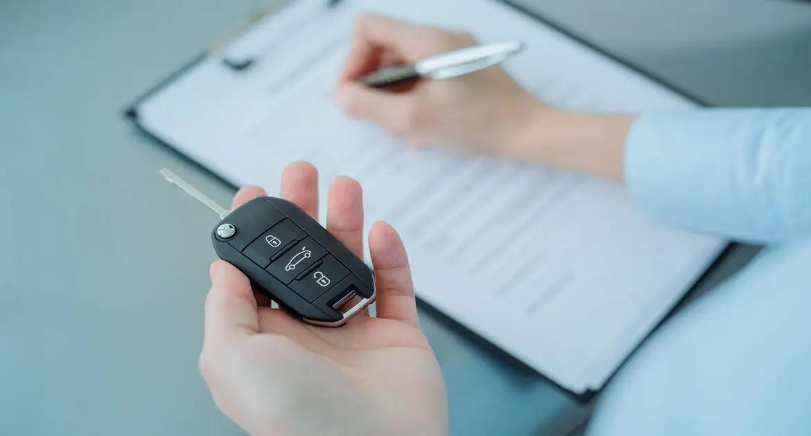 Mulher escrevendo com uma chave de carro na mão Mulher escrevendo com uma chave de carro na mão
